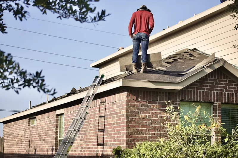 Professional roofer working on a residential roof in Glen Echo